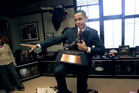 The Prez striking the "Heisman" pose with his trophy in one 